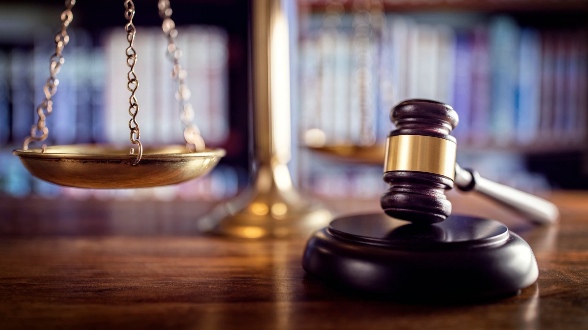 Judge gavel, scales of justice and law books in court.